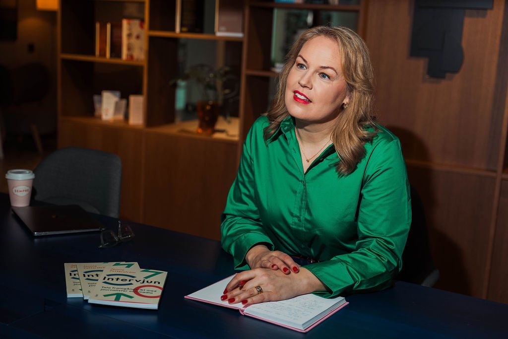 Jennie Zetterström vid ett bord med boken Intervjun